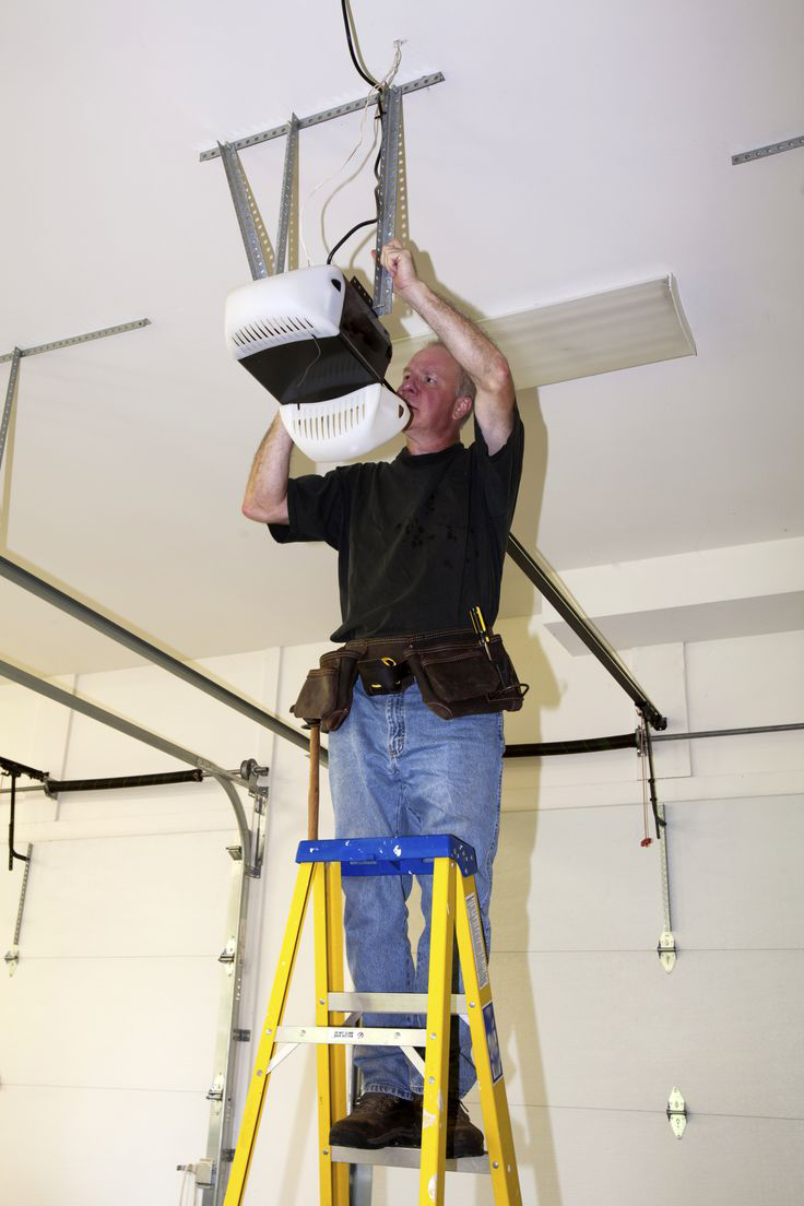  Technician performing maintenance on a garage door opener in Baltimore, MD, ensuring optimal performance and safety. 