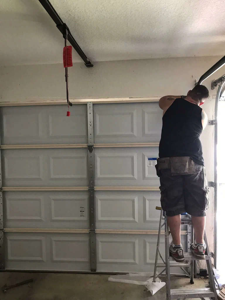 Professional technician installing and repairing a garage door opener in Baltimore, MD, ensuring efficient and secure operation.