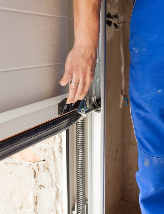 Technician repairing a broken garage door in Baltimore