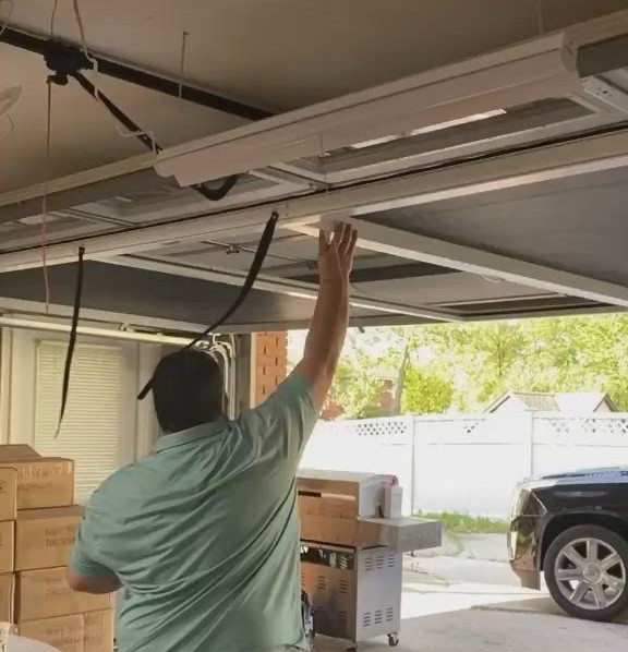Expert technician safely replacing high-tension garage door springs in Baltimore, MD, ensuring reliable operation.